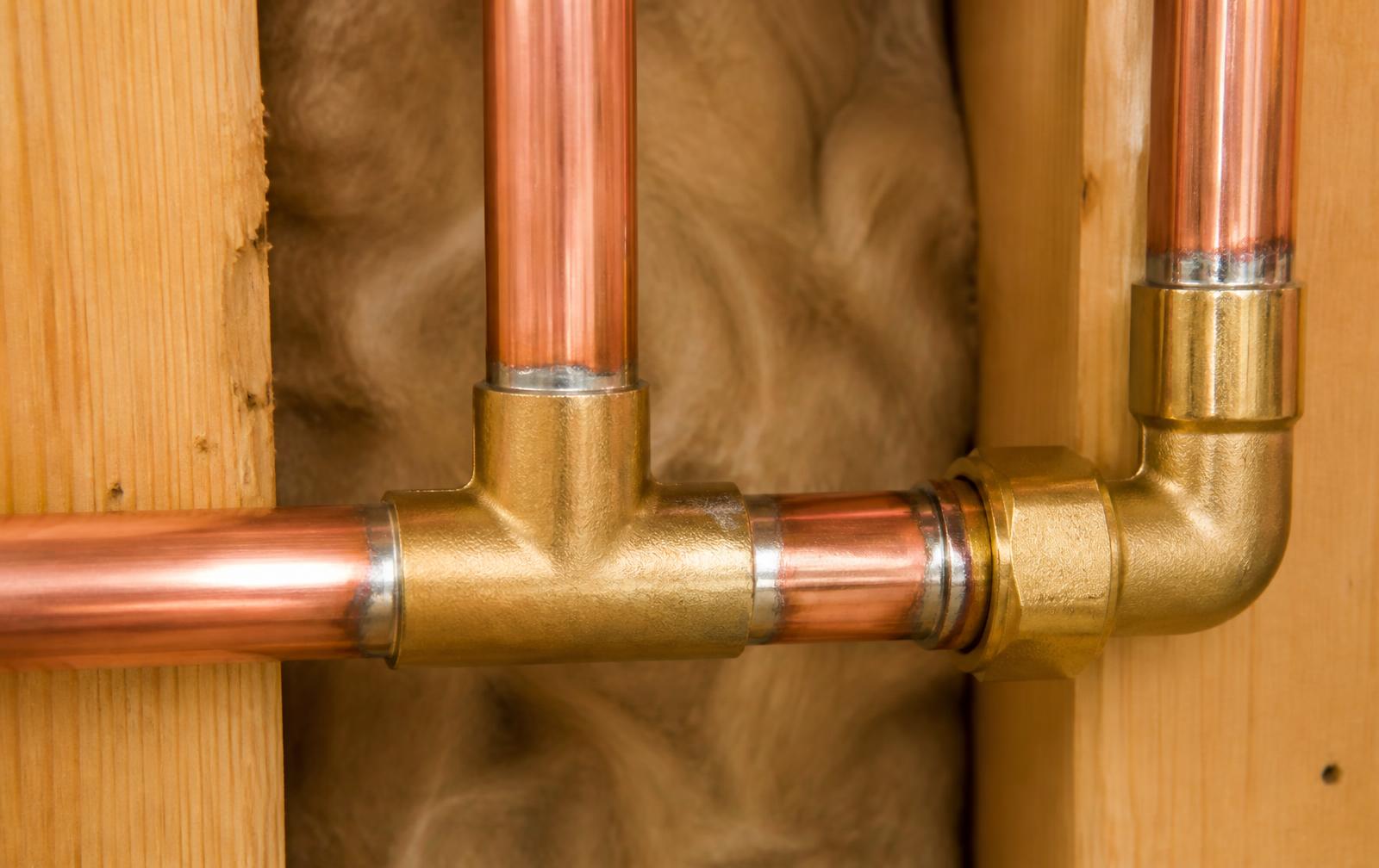 New copper water supply lines and brass fittings installed in a St. Petersburg home wall cavity during a repipe