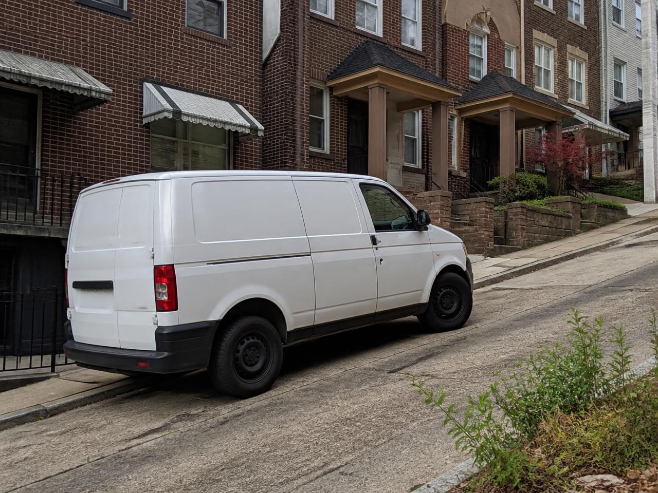 Contractor's service van parked on a steep Pittsburgh hillside street