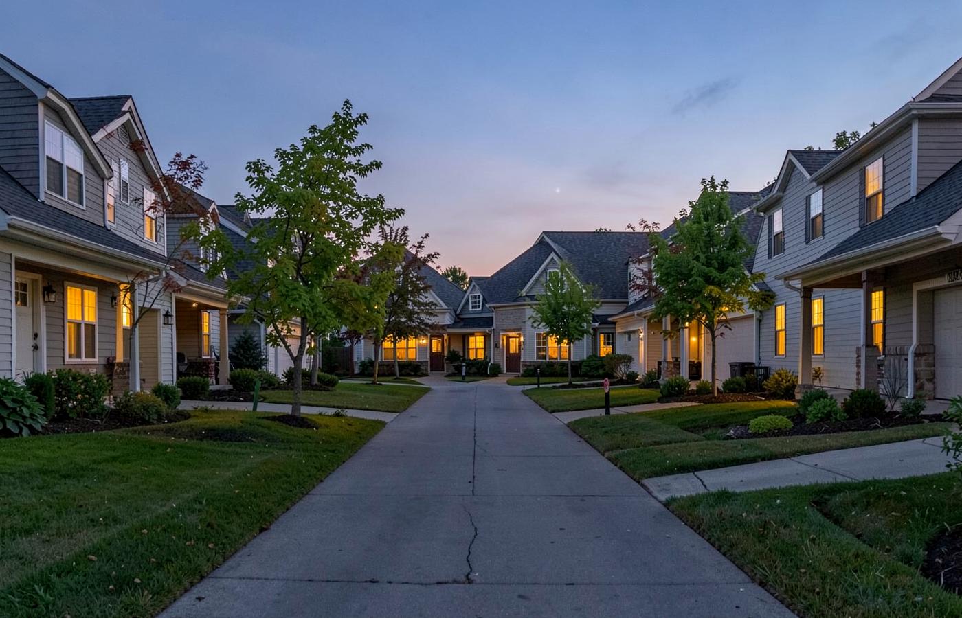 Quiet suburban cul-de-sac of brick and vinyl two-story homes with young trees and wide driveways