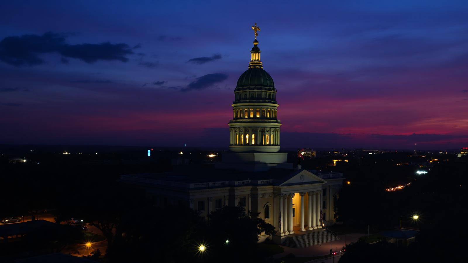 The Florida State Capitol in Tallahassee lit at dusk above the city skyline