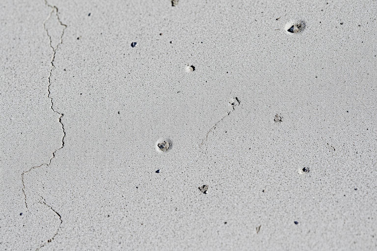 Close-up of a smooth troweled concrete patio surface catching low evening light