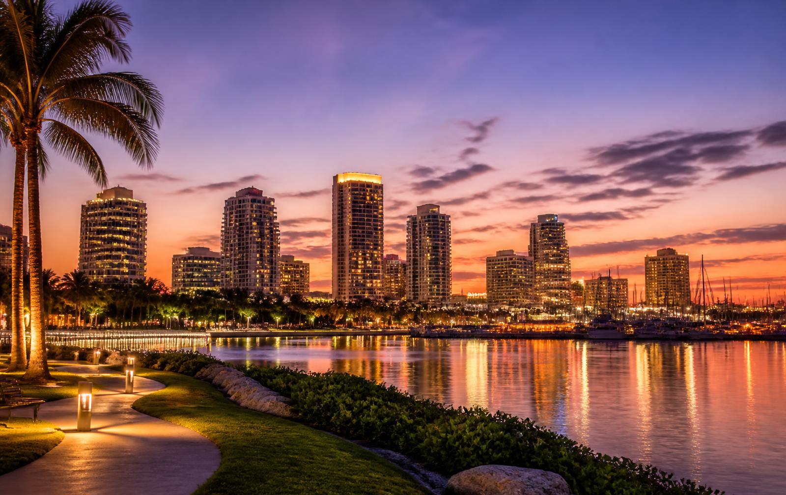 Downtown St. Petersburg at dusk seen from the waterfront park with lit high-rises reflected in the bay