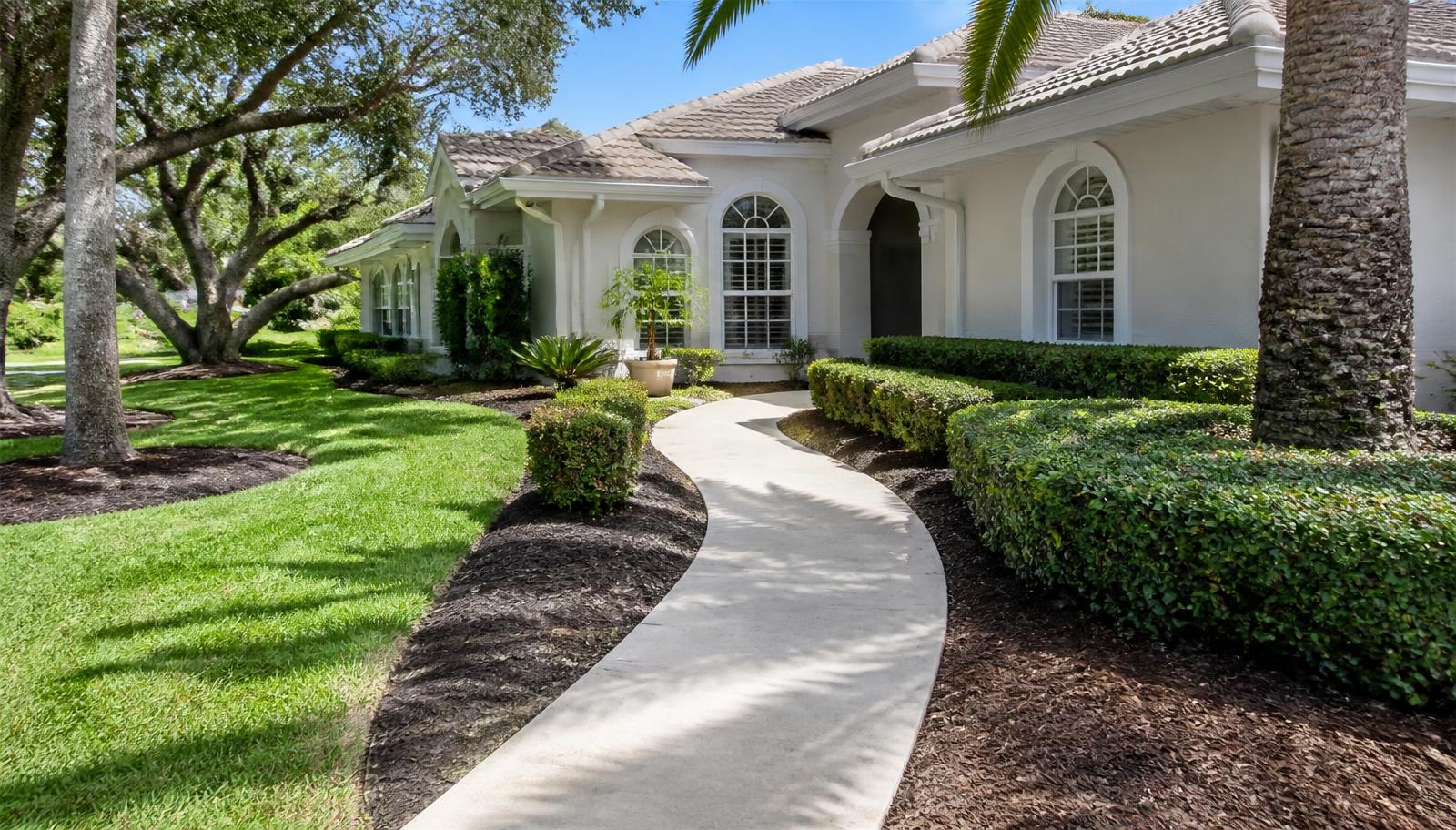Freshly finished concrete walkway and trimmed landscaping at a Tallahassee home, completed local service work