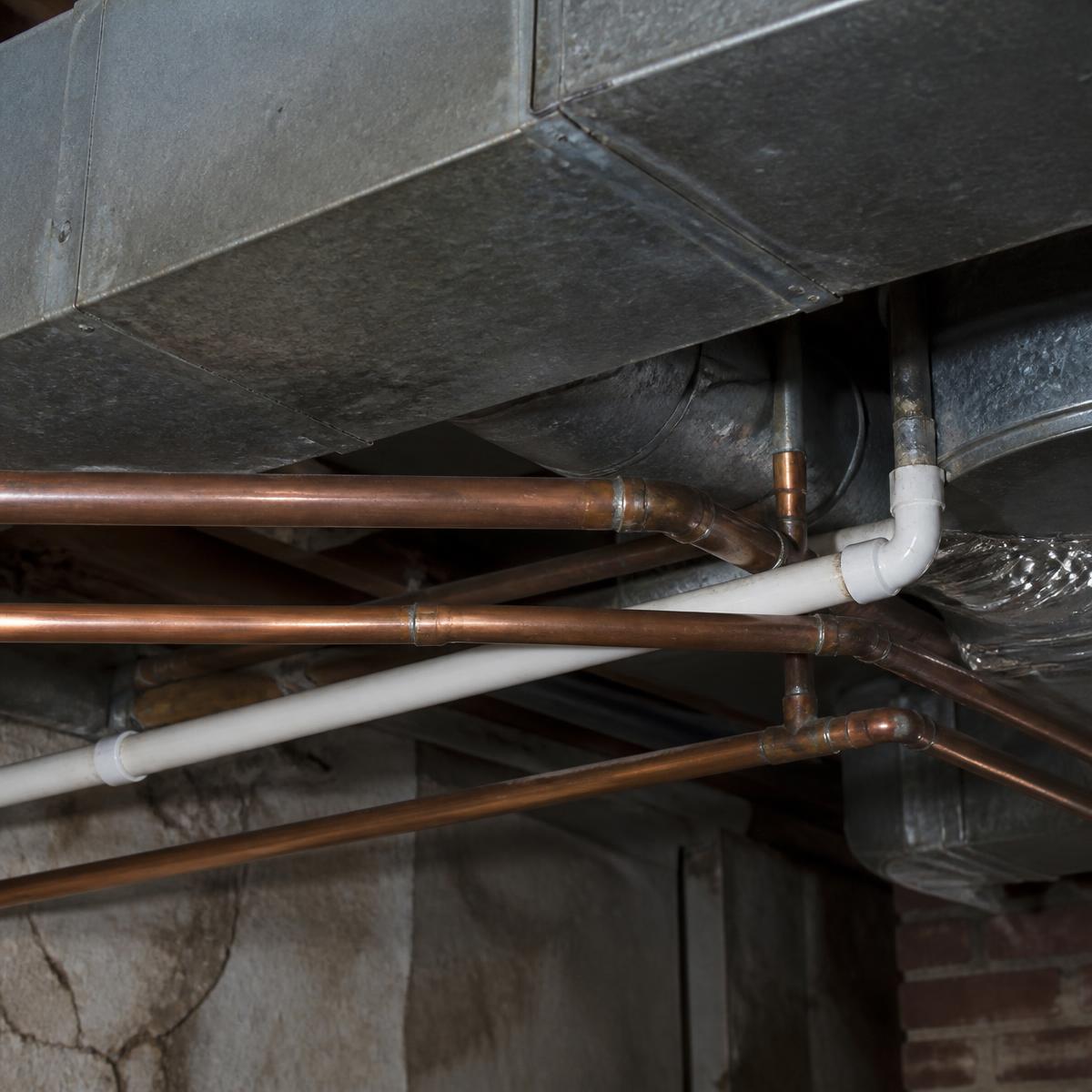 Furnace tucked into a low-clearance basement mechanical space in an Erie frame home