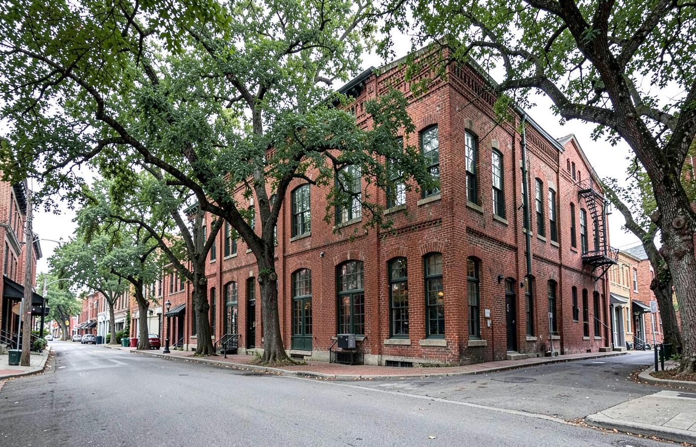 Restored red brick former textile mill building with tall windows converted to apartments