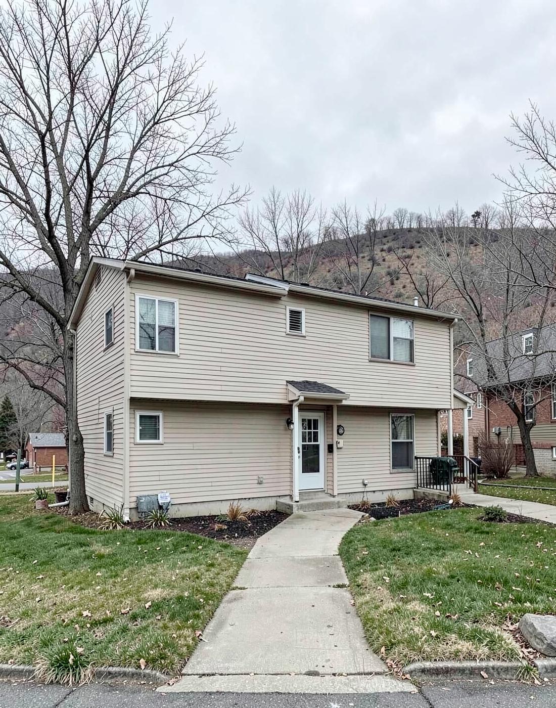 Simple two-unit duplex with plain siding and a shared front walk in a university neighborhood