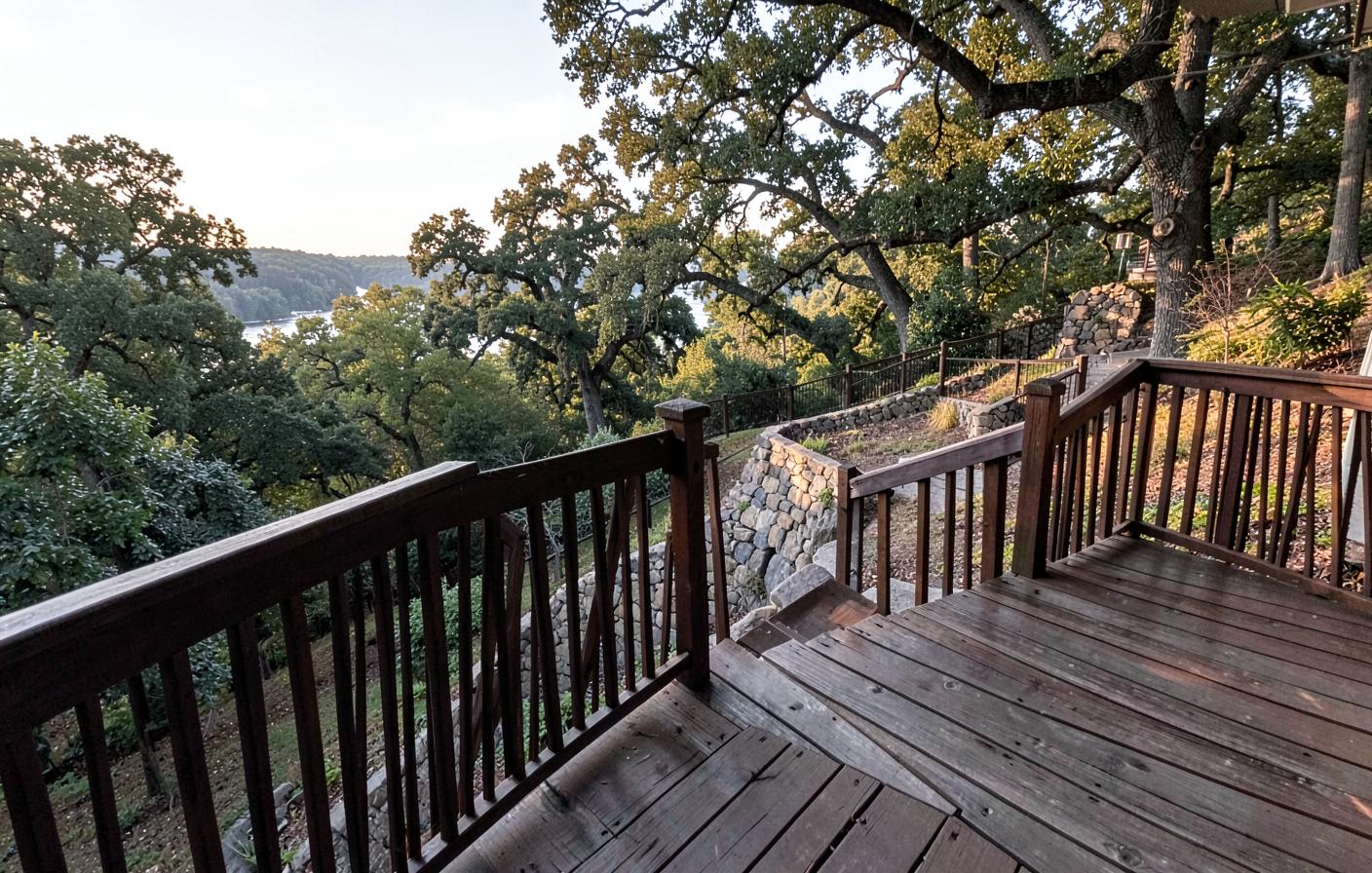 Wooden hilltop deck overlooking a sloped backyard with a retaining wall on a Peoria bluff lot