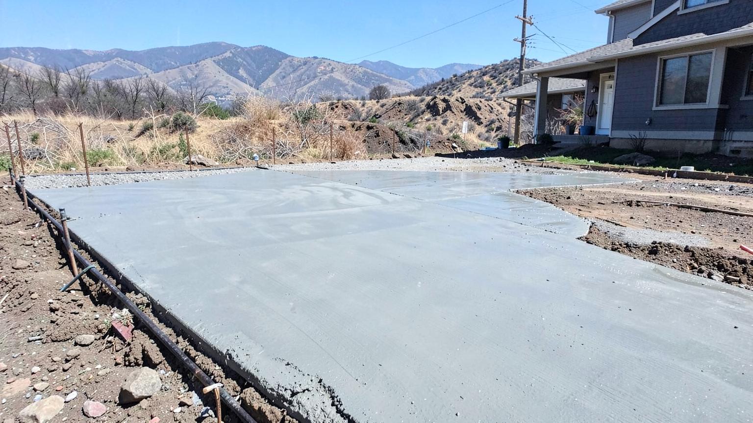 Wet concrete being smoothed with a float on a residential driveway pour on a clear cool day