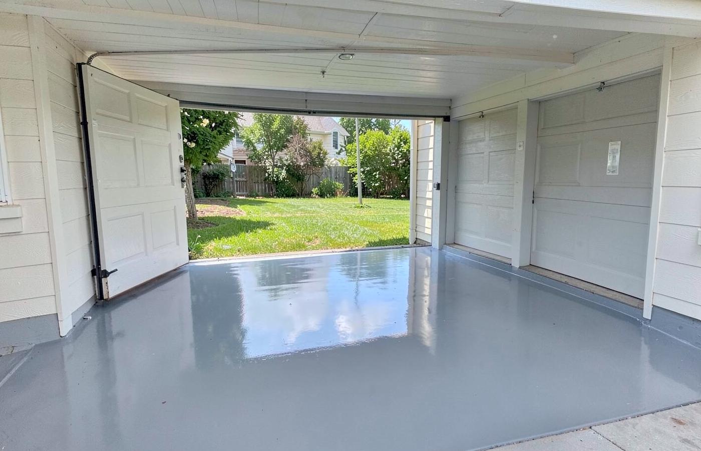 Freshly coated gray epoxy garage floor in an empty residential two-car garage