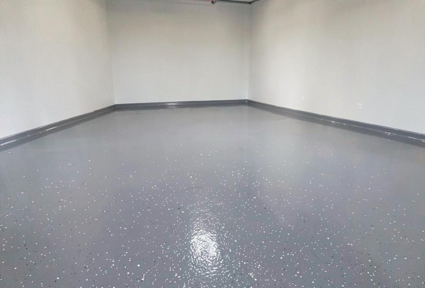 Freshly coated glossy grey epoxy garage floor reflecting daylight from an open garage door